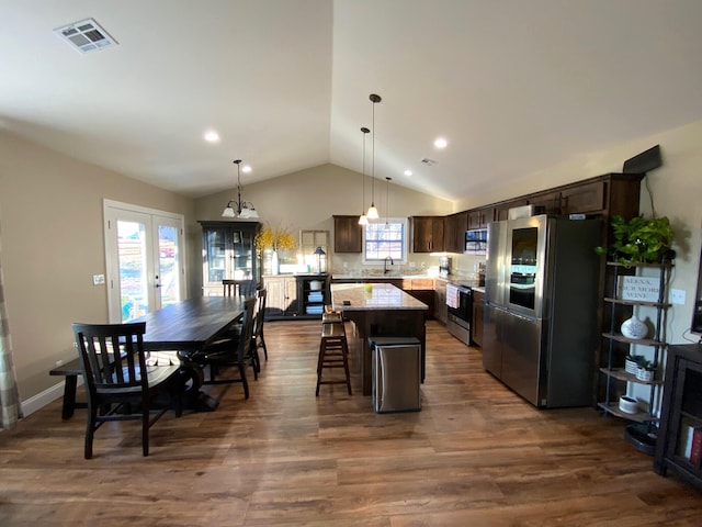 2520 S Schifferdecker Ave, Joplin, MO 64804 - kitchen with visible vents, a kitchen island, stainless steel appliances, dark brown cabinetry, and dark wood-style flooring