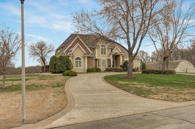 304 Reavley Dr, Lamar, MO 64759 - view of front of house featuring curved driveway, a front lawn, and stucco siding