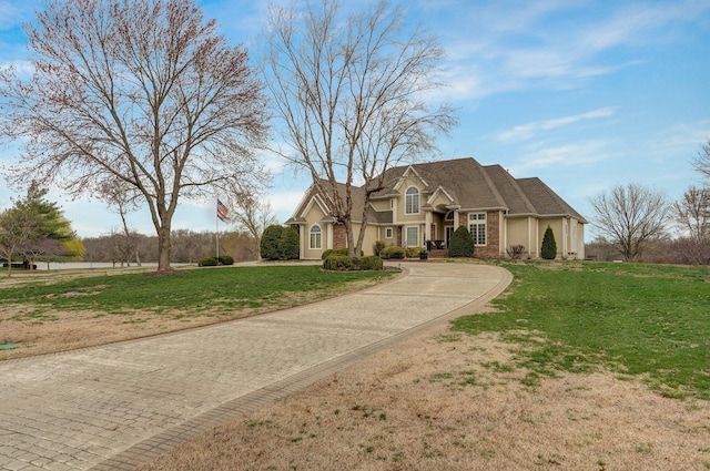 304 Reavley Dr, Lamar, MO 64759 - view of front of property featuring stucco siding, curved driveway, and a front lawn