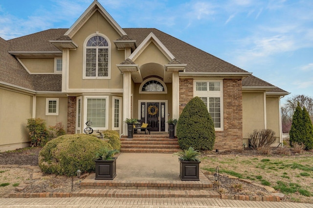 304 Reavley Dr, Lamar, MO 64759 - traditional home with stucco siding, brick siding, and a shingled roof