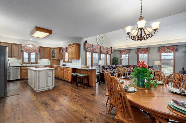 304 Reavley Dr, Lamar, MO 64759 - dining area featuring dark wood-type flooring, a notable chandelier, and lofted ceiling