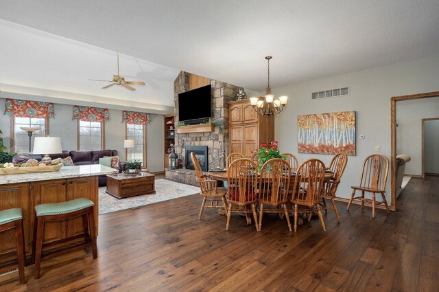304 Reavley Dr, Lamar, MO 64759 - dining space featuring visible vents, dark wood-type flooring, ceiling fan with notable chandelier, a fireplace, and lofted ceiling