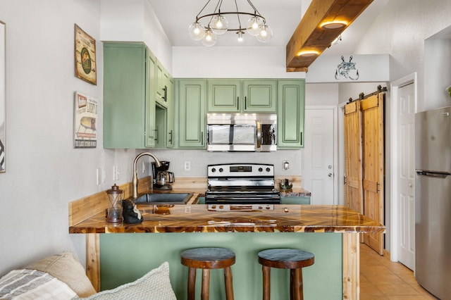 kitchen with a sink, butcher block counters, stainless steel appliances, and green cabinetry