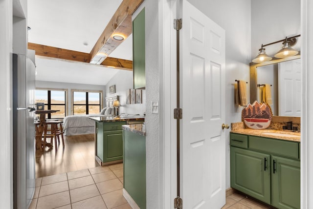 hallway with a sink, light tile patterned flooring, and vaulted ceiling with beams