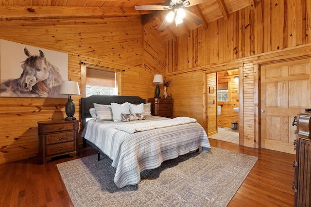 bedroom featuring ceiling fan, beamed ceiling, wood walls, wooden ceiling, and wood finished floors