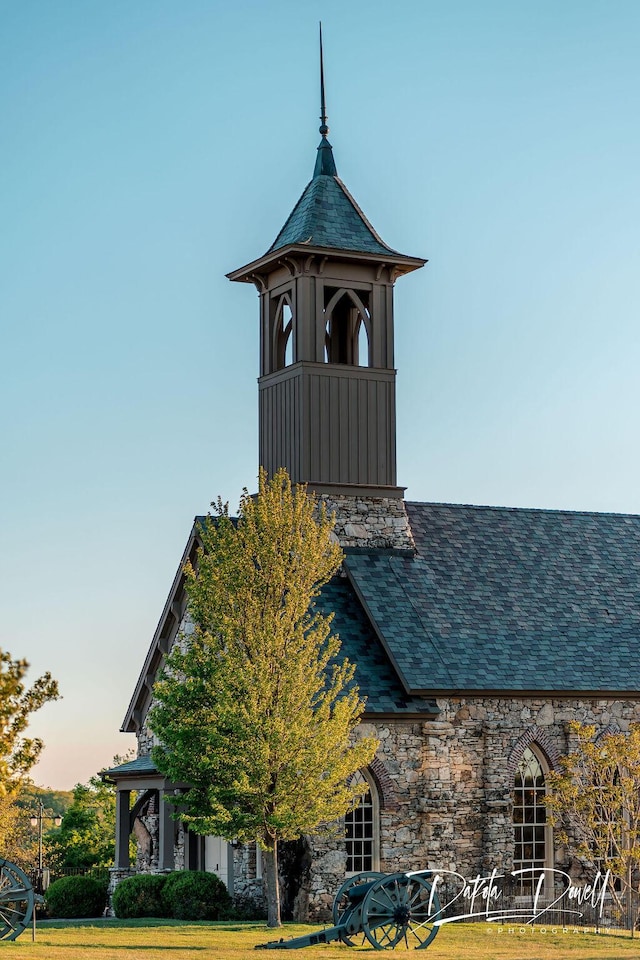 details with stone siding and a shingled roof