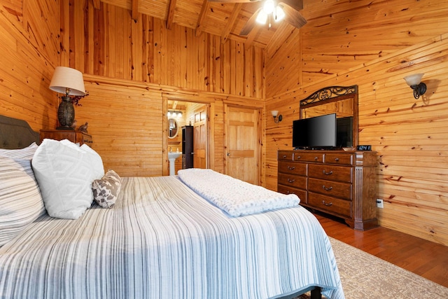 bedroom with wooden walls, wooden ceiling, lofted ceiling with beams, and wood finished floors
