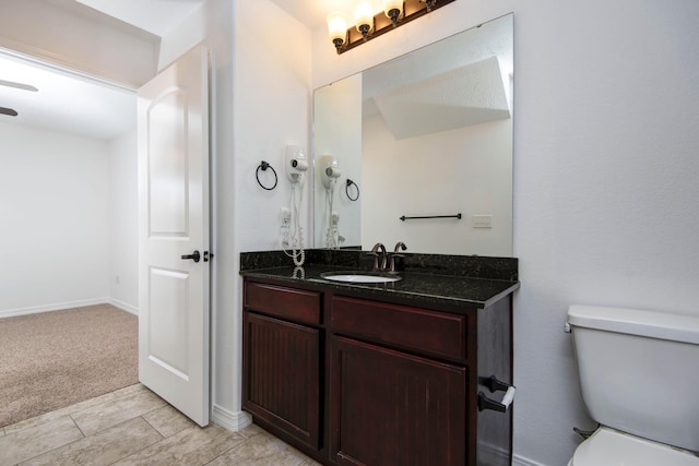 bathroom with baseboards, toilet, and vanity