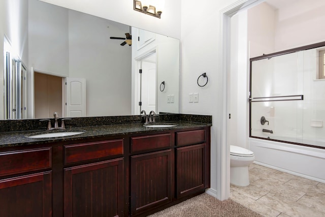 bathroom featuring double vanity, toilet, ceiling fan, and a sink