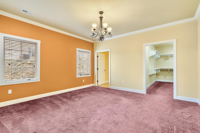 carpeted empty room with a chandelier, visible vents, baseboards, and ornamental molding