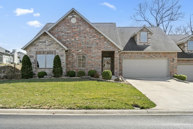 view of front of home featuring a front lawn, roof with shingles, a garage, stone siding, and driveway