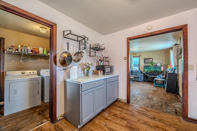 laundry area with washer and clothes dryer, laundry area, and wood finished floors