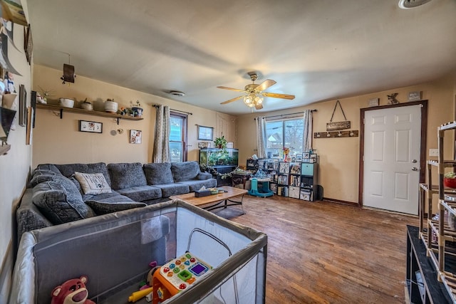 living area with a ceiling fan and wood finished floors