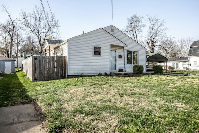 view of front of home with a carport, fence, and a front yard