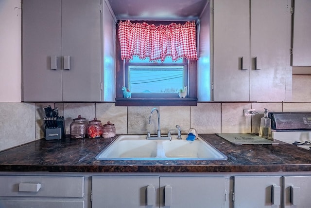 kitchen with decorative backsplash, range, and a sink