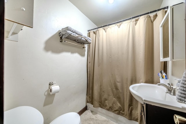bathroom featuring shower / bathtub combination with curtain, toilet, and vanity