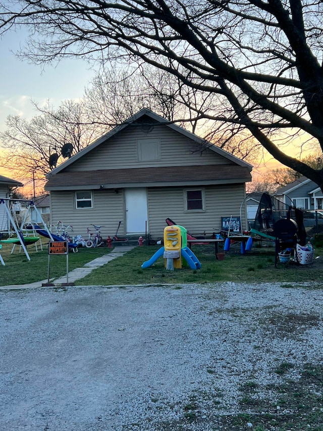 317 Mc Connell Ave, Joplin, MO 64801 - back of house at dusk featuring a playground and a yard