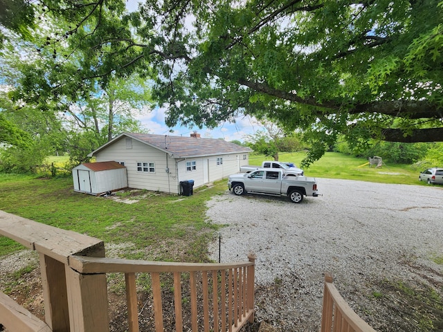 1622 W Fairview Ave, Carthage, MO 64836 - view of side of property featuring a lawn, a garage, and gravel driveway