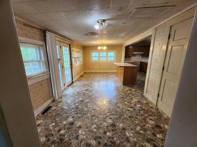 1622 W Fairview Ave, Carthage, MO 64836 - kitchen featuring wallpapered walls, a chandelier, ventilation hood, a center island, and stone finish floors