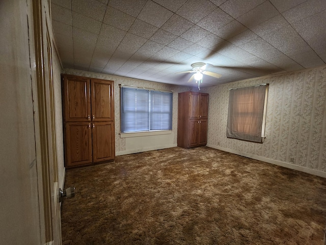 1622 W Fairview Ave, Carthage, MO 64836 - unfurnished bedroom with dark colored carpet, wallpapered walls, baseboards, and a ceiling fan