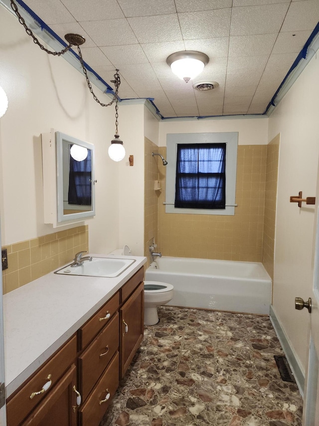 1622 W Fairview Ave, Carthage, MO 64836 - bathroom featuring vanity, toilet, bathing tub / shower combination, stone finish flooring, and decorative backsplash