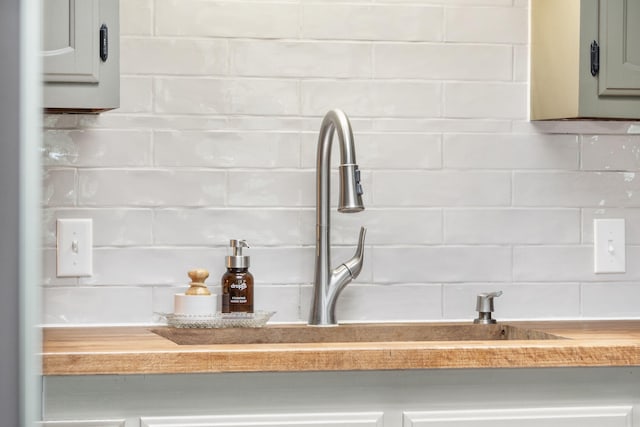 details featuring tasteful backsplash, light countertops, and a sink