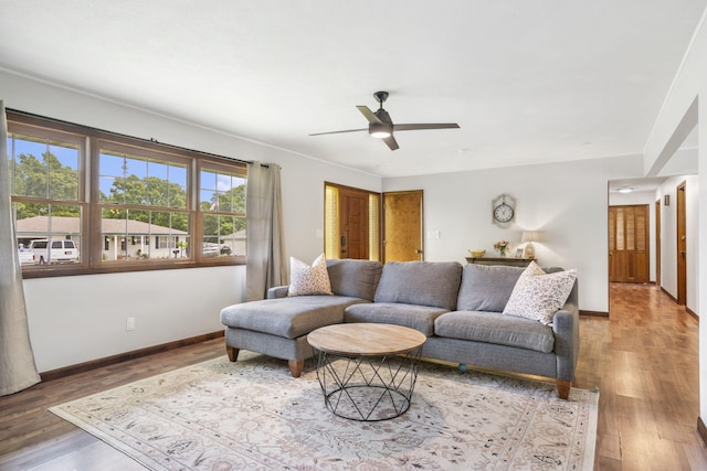 living room featuring baseboards, wood finished floors, and ceiling fan