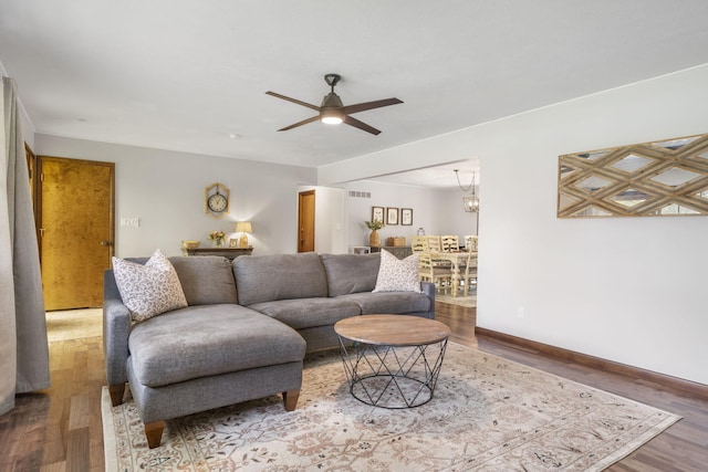 living area with visible vents, a ceiling fan, and wood finished floors