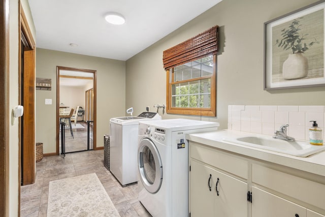 laundry area with cabinet space, washer and dryer, and a sink