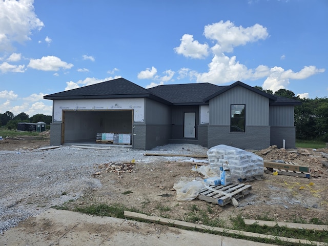 123 E Teakwood Ave, Clever, MO 65631 - view of front of house with a garage, brick siding, and gravel driveway