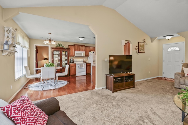 living area with arched walkways, an inviting chandelier, baseboards, and vaulted ceiling