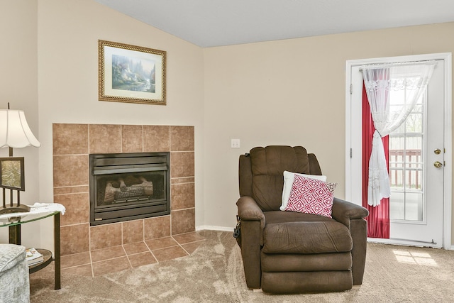 living area with a tiled fireplace and carpet floors