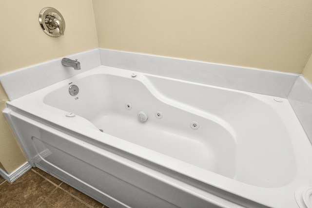 full bath featuring a whirlpool tub and tile patterned flooring