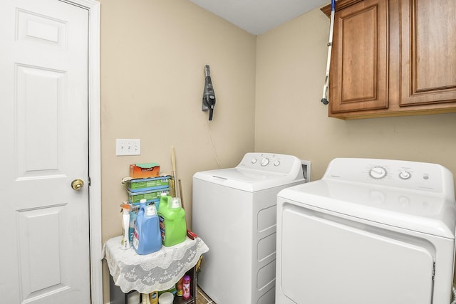 laundry room featuring separate washer and dryer and cabinet space