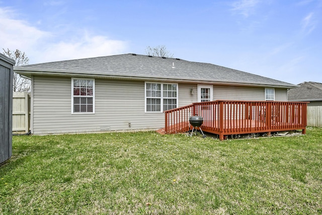 rear view of property with a yard, fence, and a shingled roof