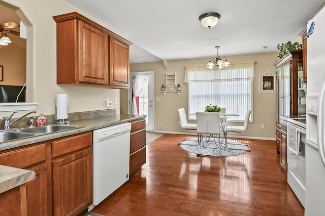 kitchen with baseboards, white dishwasher, a sink, dark wood-style flooring, and brown cabinets