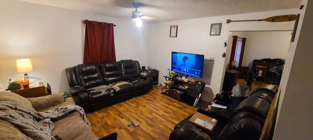 living room with a ceiling fan and wood finished floors