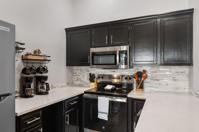 235 Ozark Mountain Resort Dr Unit 47, Kimberling City, MO 65686 - kitchen with light countertops, tasteful backsplash, dark cabinets, and appliances with stainless steel finishes