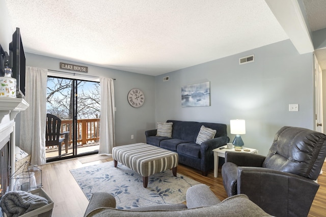 145 Starboard Dr Unit 8, Kimberling City, MO 65686 - living area featuring a textured ceiling, wood finished floors, and a fireplace with flush hearth