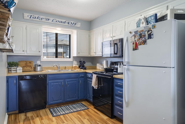 145 Starboard Dr Unit 8, Kimberling City, MO 65686 - kitchen featuring black appliances, blue cabinetry, a sink, light countertops, and light wood-type flooring