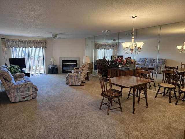 300 Port Dr Unit 5, Kimberling City, MO 65686 - dining room featuring ceiling fan with notable chandelier, a tiled fireplace, carpet flooring, and a textured ceiling