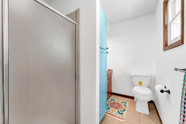 full bathroom featuring a shower stall, vanity, baseboards, toilet, and tile patterned flooring