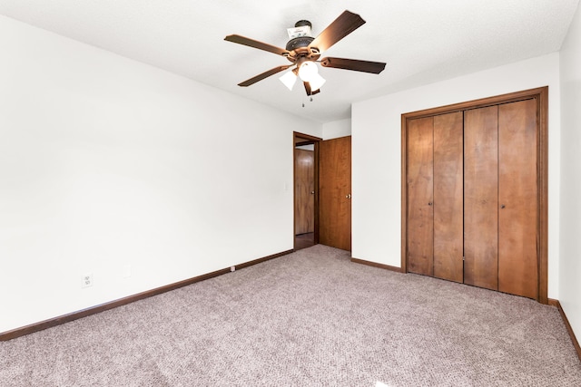 unfurnished bedroom with a ceiling fan, baseboards, a closet, and light colored carpet