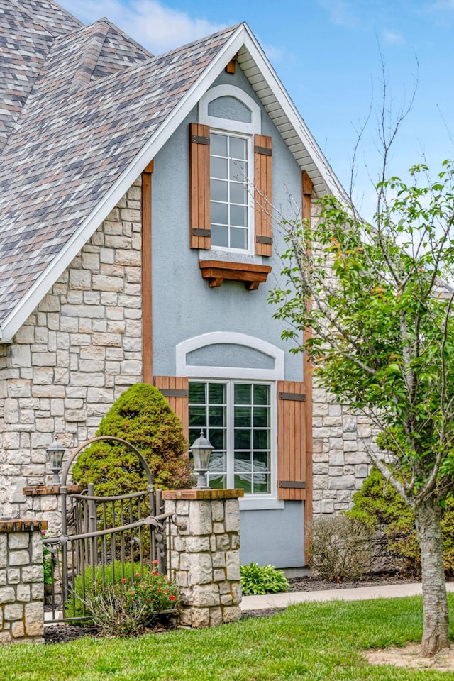 9041 N Country Manor Ln, Fair Grove, MO 65648 - view of side of property with stone siding, stucco siding, fence, and a shingled roof