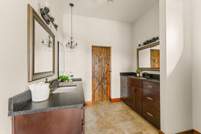 full bathroom with double vanity, baseboards, and a sink