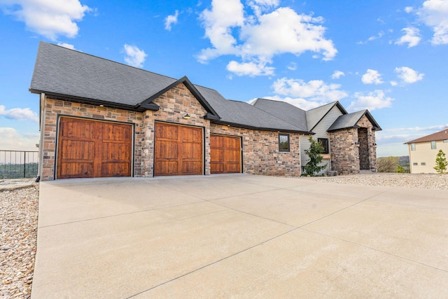 craftsman inspired home with a garage, roof with shingles, fence, stone siding, and concrete driveway