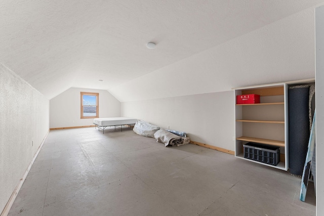 additional living space with baseboards and lofted ceiling