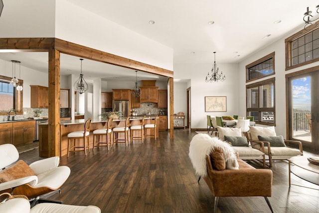 living area featuring recessed lighting, a notable chandelier, dark wood-style flooring, and a high ceiling