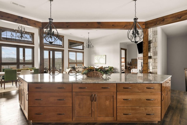 kitchen with an inviting chandelier, light stone counters, dark wood-type flooring, visible vents, and beam ceiling