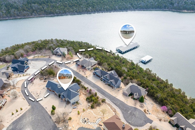 bird's eye view featuring a wooded view, a residential view, and a water view